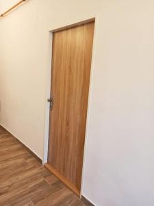 eine Holztür in einem Zimmer mit Holzboden in der Unterkunft Apartmán Kostomlaty pod Milešovkou in Kostomlaty pod Milešovkou