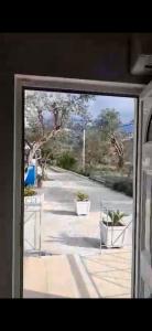 una ventana con vistas a una calle con plantas en VANGJELIS HOTEL, en Himare