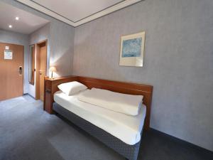 een slaapkamer met een bed in een kamer bij B&B HOTEL Gotha-Hbf in Gotha