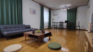 sala de estar con sofá y mesa en SecondHouse Otaru Garden, en Otaru