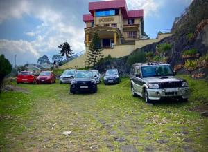 a group of cars parked in front of a house at RAHUL STONE PALACE in Kodaikānāl