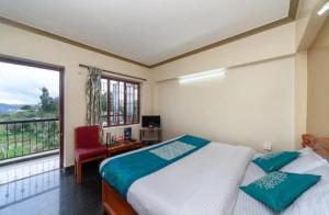 a bedroom with a bed and a large window at RAHUL STONE PALACE in Kodaikānāl