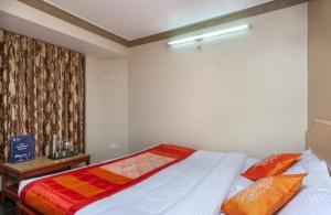 a bedroom with a bed with orange pillows at RAHUL STONE PALACE in Kodaikānāl