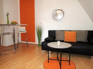 a living room with a black couch and a table at Appartement Föhrenvilla in Mödling