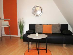 a living room with a black couch and a table at Appartement Föhrenvilla in Mödling