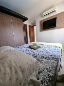 ein Schlafzimmer mit einem Bett mit einer Decke darauf in der Unterkunft Flat Hotel Veredas Rio Quente Hot Park apto 216, 323 e 522 in Rio Quente