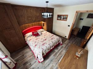 a bedroom with a bed with a red head board at Chalet Chez Louis - Alpine Charm with Mont Blanc View & Ski Access in Courmayeur