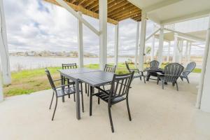 een tafel en stoelen op een veranda met uitzicht op het water bij Water Front 3 25 Bath Kingbed Kemah Seabrook in Seabrook