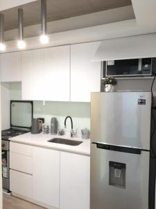 a kitchen with white cabinets and a stainless steel refrigerator at Departamento Ejecutivo a Estrenar in Buenos Aires