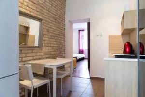 una cucina con tavolo, sedie e muro di mattoni di Romantic Central Flat a Bratislava