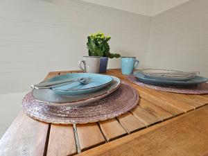 a wooden table with two blue plates on it at Baumhaus und Tinyhaus in Mühlhausen