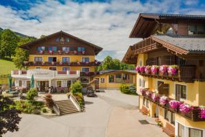 - une vue sur un bâtiment avec des fleurs sur les balcons dans l'établissement Der Burgfellnerhof - Adults Only, à Schladming