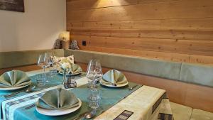 a table with a blue table cloth and plates and glasses at Guesthouse Pri Zalogarju in Železniki