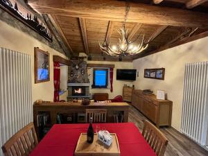 a dining room with a table and chairs and a television at Chalet Chez Louis - Alpine Charm with Mont Blanc View & Ski Access in Courmayeur