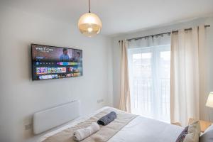 um quarto com uma cama e uma televisão na parede em Reading 2-Bed Apartment & Parking em Reading