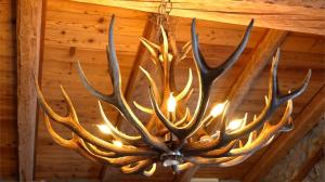 a chandelier with antlers hanging from a ceiling at Chalet Chez Louis - Alpine Charm with Mont Blanc View & Ski Access in Courmayeur