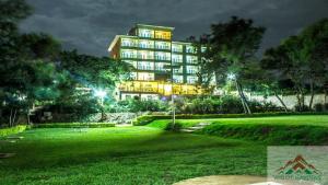 Un grand bâtiment est éclairé la nuit. dans l'établissement Wigot Gardens Hotel, à Kisumu