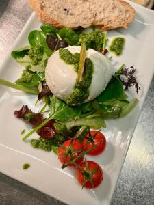 a plate with a salad with a dollop of ice cream and vegetables at Hotel Hinrichs in Carolinensiel