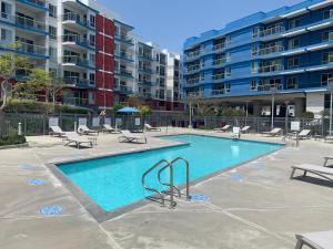 uma piscina com cadeiras e um edifício em Venice Beach Lux Retreat Coastal Apartment Haven em Los Angeles