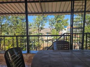 een afgeschermde veranda met een tafel en twee stoelen bij Seven Villa with Swimming pool in Panchgani