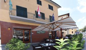 a restaurant with tables and umbrellas in front of a building at Albergo La Perla in Orbetello