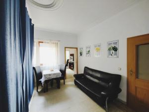 sala de estar con sofá negro y mesa en The ARK Eco Homestay, en Esch-sur-Alzette