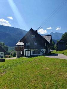 une maison au sommet d'un champ verdoyant dans l'établissement Ferienhaus Asterbach, à Gosau