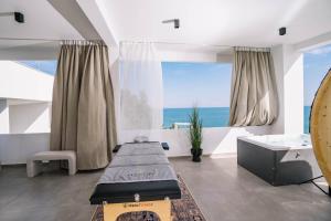 a room with two beds and a view of the ocean at Akrotiri Olympus Luxury Suites - Adults Only in Plaka Litochorou