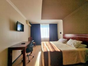 een hotelkamer met een bed en een bureau met een computer bij Hotel El Araucano in Concepción