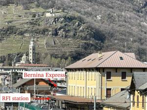 una ciudad con una montaña en el fondo con edificios en Bernina Suites - vicino al Bernina Express, en Tirano