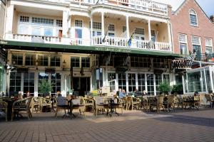 eine Außenterrasse mit Tischen und Stühlen vor einem Gebäude in der Unterkunft Hotel Grand Cafe Deight in Zandvoort