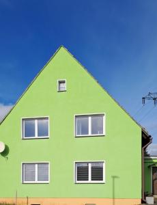 une maison verte avec des fenêtres blanches au-dessus dans l'établissement Ferienhaus „Zum alten Fröhlich“, à Dresde