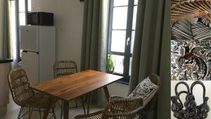 een eetkamer met een tafel en stoelen en een koelkast bij Villa Sérénité appartement au centre ville n 4 in Lourdes