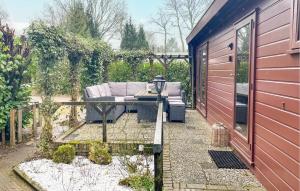 een patio met een bank en een tafel in een tuin bij 1 Bedroom Cozy StaCaravan In Putten in Putten