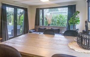 een grote houten tafel in een kamer met stoelen bij 1 Bedroom Cozy StaCaravan In Putten in Putten