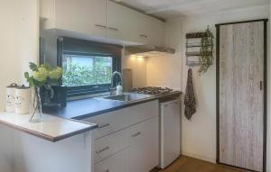 een kleine keuken met een wastafel en een raam bij 1 Bedroom Cozy StaCaravan In Putten in Putten