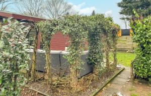 een tuin met een hot tub bedekt met klimop bij 1 Bedroom Cozy StaCaravan In Putten in Putten