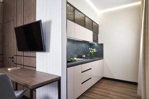 cocina con mesa y TV en la pared en BonApart Maidan by UHM, en Kiev