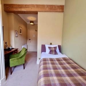 una camera con letto, scrivania e sedia verde di Loch Maree Hotel a Talladale