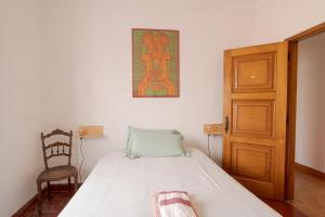 1 dormitorio con 1 cama y puerta de madera en Manas Coliving, en Sines