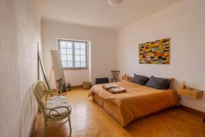 1 dormitorio con 1 cama y una pintura en la pared en Manas Coliving, en Sines