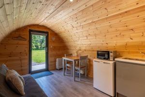 Ce chalet en rondins comprend une cuisine et une table. dans l'établissement Mount Hillary Holiday Pods, à Cork