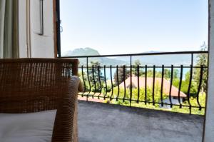 a chair on a balcony with a view of the ocean at Hotel du Lac in Talloires