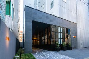 um grande edifício de vidro com vasos de plantas à sua frente em HOTEL FORZA HAKATAEKI CHIKUSHIGUCHI Ⅱ em Fukuoka