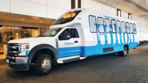 um autocarro branco e azul estacionado num centro comercial em Hilton Los Angeles Airport em Los Angeles