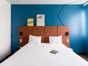 A bed or beds in a room at Ibis Rouen Centre Rive Gauche Mermoz