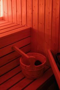 - un seau rouge assis dans un sauna en bois dans l'établissement 4ry pokoje, à Cieszyn