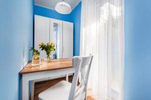 une salle à manger avec des murs bleus et une table avec une chaise blanche dans l'établissement Oliwia, à Jastrzębia Góra