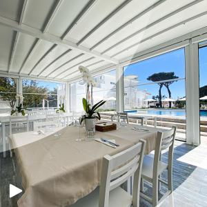 a white dining room with a table with white chairs at Female Resort in San Felice Circeo