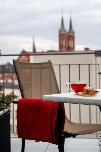 a table and chair with a plate of food on a balcony at Hotel Esperanto in Białystok